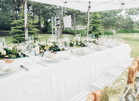 beautifully set outdoor dinner table under white canopy